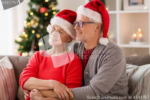 Image of happy senior couple in santa hats at christmas