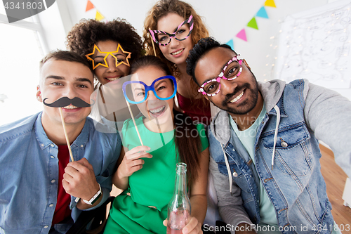 Image of happy friends having fun at home party