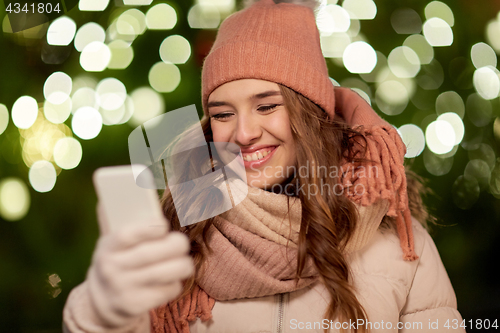 Image of happy woman with smartphone at christmas