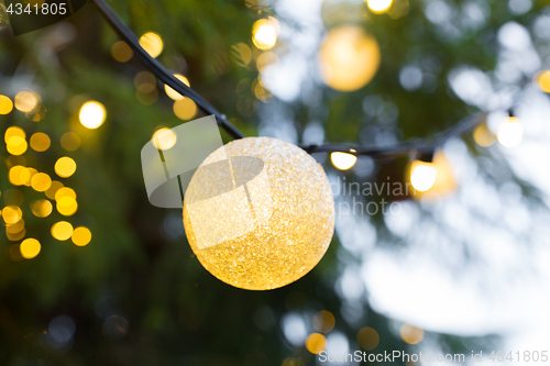 Image of close up of christmas tree garland bulb outdoors