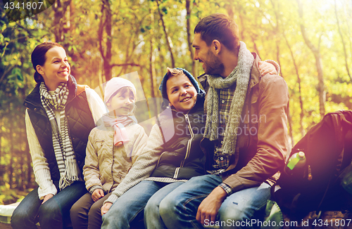 Image of happy family sitting on bench and talking at camp