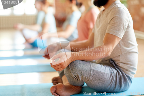 Image of group of people making yoga exercises at studio