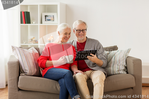 Image of happy senior couple with tablet pc at christmas