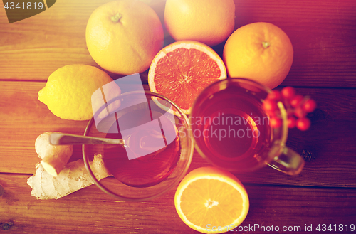 Image of ginger tea with honey, citrus and garlic on wood