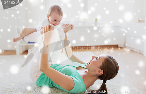 Image of happy mother playing with baby at home