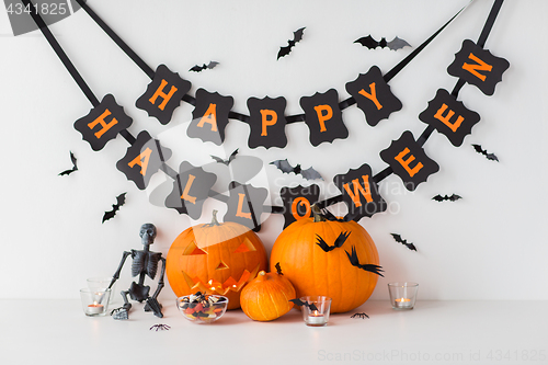 Image of carved pumpkins with candies and halloween garland