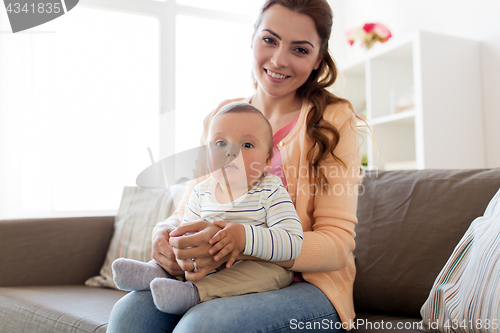 Image of happy young mother with little baby at home