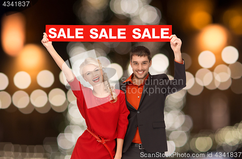 Image of couple with red sale sign over christmas lights