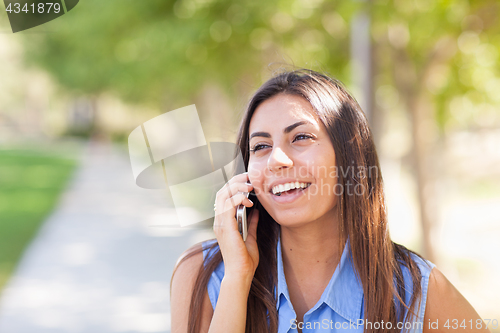 Image of Beautiful Young Ethnic Woman Talking on Her Smartphone Outside.