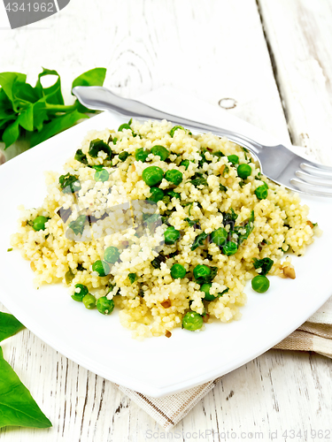 Image of Couscous with spinach in plate on board