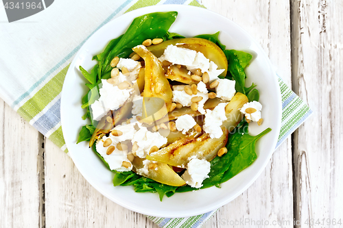 Image of Salad from pear and spinach in dish on light board top