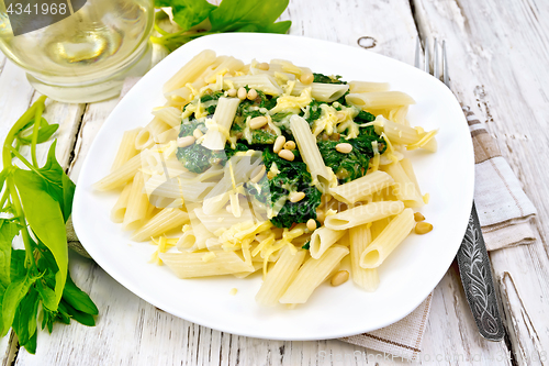 Image of Pasta penne with spinach and nuts on board