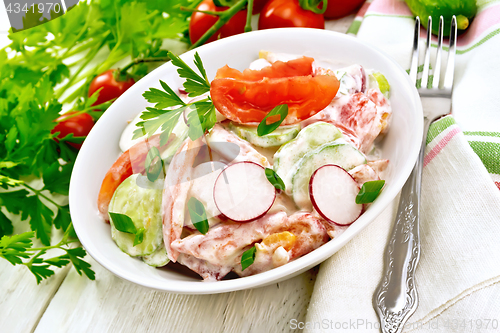 Image of Salad from fresh vegetables with greens in plate on board