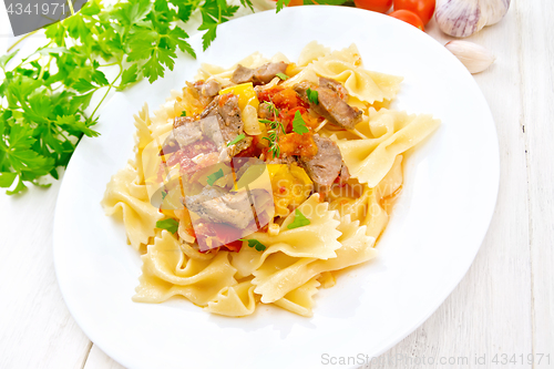 Image of Farfalle with turkey and vegetables in sauce on light board