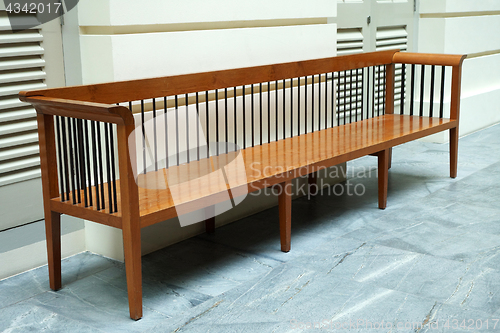 Image of Wooden bench in front of a wall