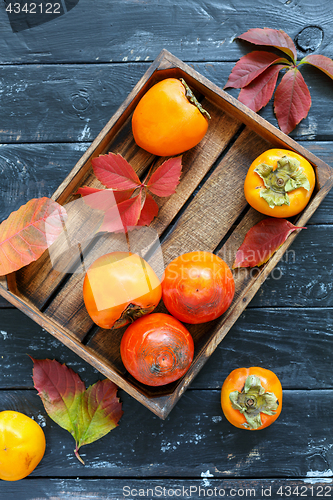 Image of Juicy persimmon in a wooden box.