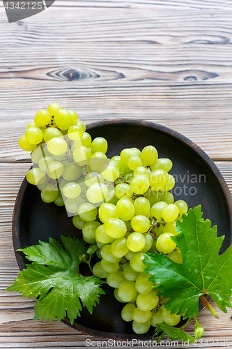 Image of Juicy white grapes in a wooden bowl.