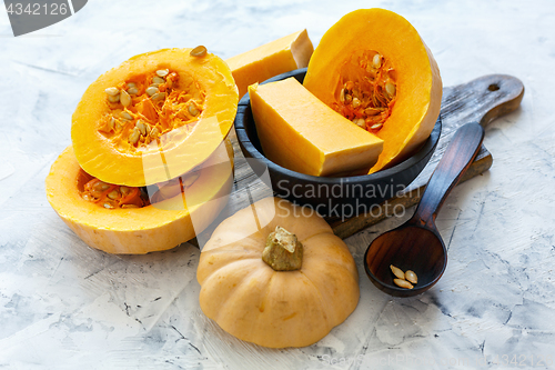 Image of Pumpkin sliced on an old wooden board.