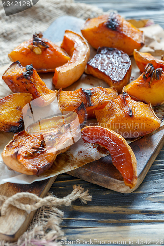 Image of Slices of pumpkin roasted with honey on a parchment.