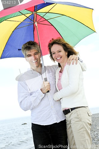Image of Happy mature couple with umbrella