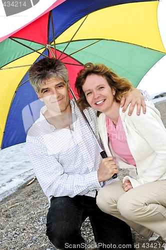 Image of Happy mature couple with umbrella