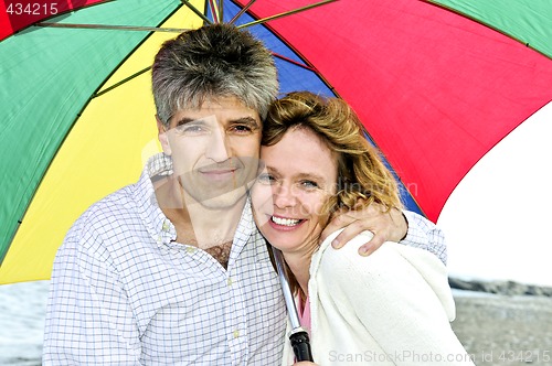 Image of Happy mature couple with umbrella