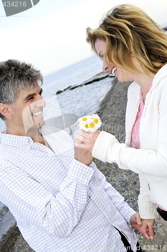 Image of Mature romantic couple with flowers