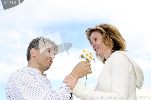 Image of Mature romantic couple with flowers