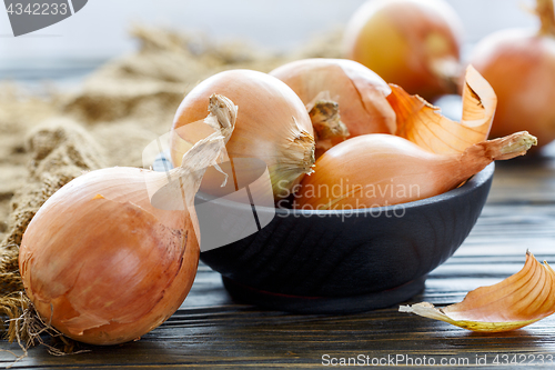 Image of Yellow onion in a wooden bowl.