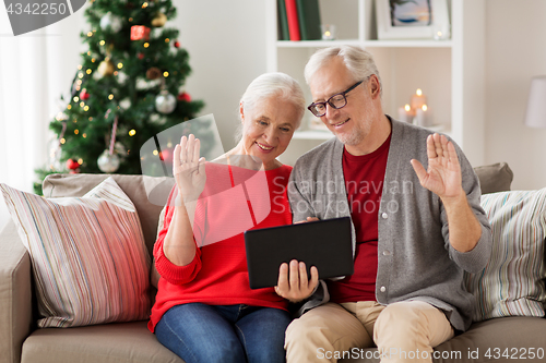 Image of happy senior couple with tablet pc at christmas