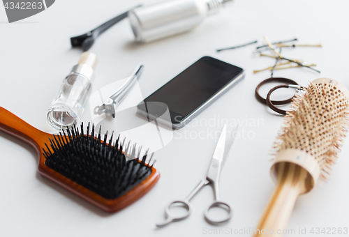 Image of smartphone, scissors, brushes and other hair tools