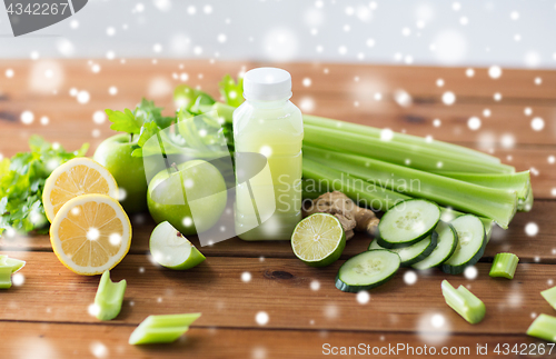 Image of bottle with green juice, fruits and vegetables