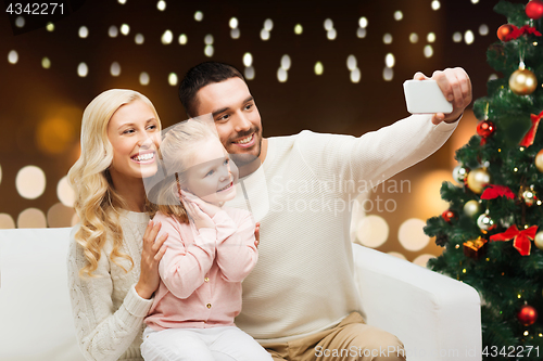 Image of family taking selfie with smartphone at christmas