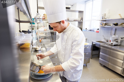 Image of happy male chef cooking food at restaurant kitchen