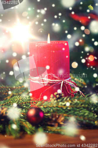 Image of fir branch wreath with candle on wooden table