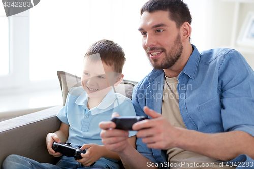 Image of father and son playing video game at home