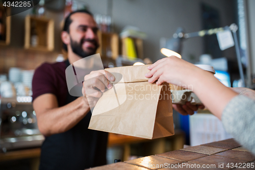 Image of man or bartender serving customer at coffee shop