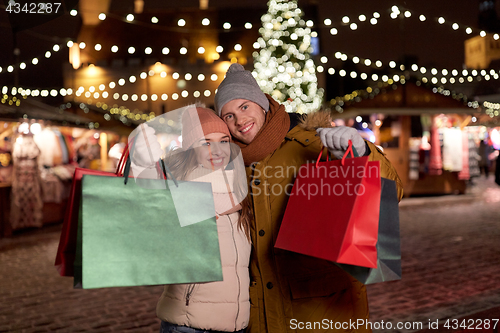 Image of happy couple at with shopping bags in winter