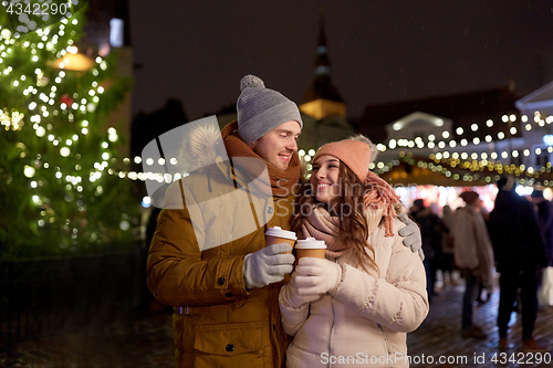 Image of happy young couple with coffee at christmas market