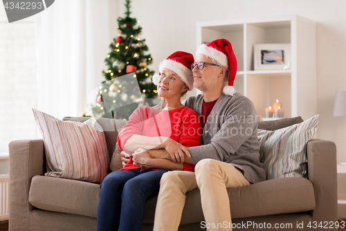 Image of happy senior couple in santa hats at christmas