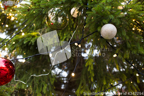 Image of close up of fir with christmas tree toys outdoors