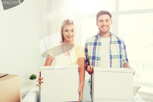 Image of smiling couple with big boxes moving to new home