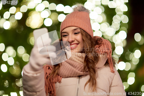 Image of happy woman with smartphone at christmas