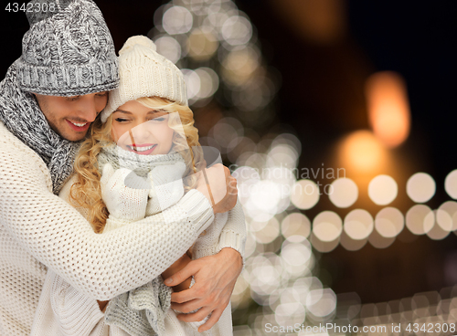 Image of happy couple hugging over christmas lights