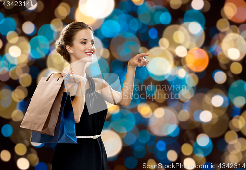 Image of happy woman in black dress with shopping bags