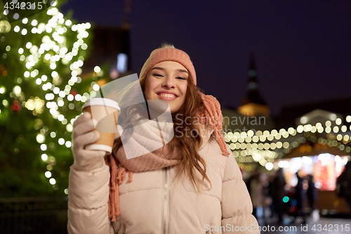 Image of happy young woman with coffee at christmas market