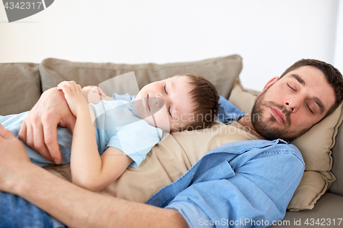 Image of happy father and son sleeping on sofa at home