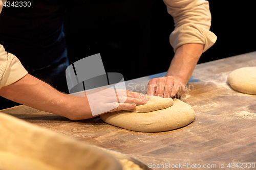 Image of chef or baker cooking dough at bakery