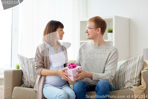 Image of husband giving birthday present to pregnant wife