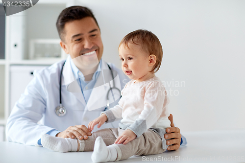 Image of happy doctor or pediatrician with baby at clinic